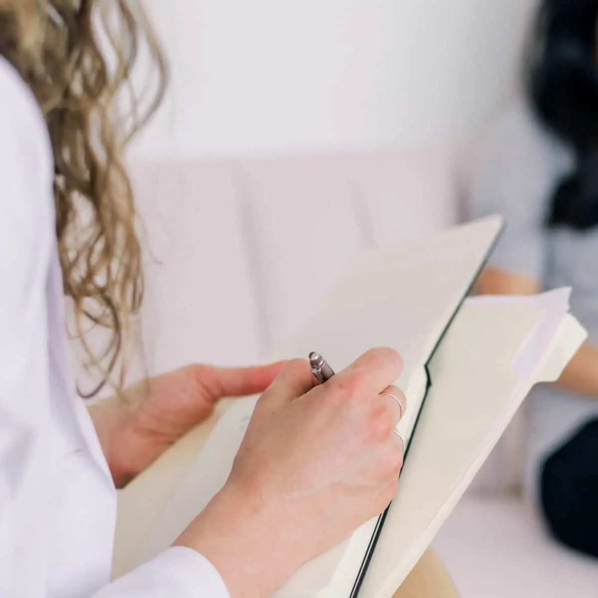 Terapeuta tomando notas durante una sesión de terapia psicológica